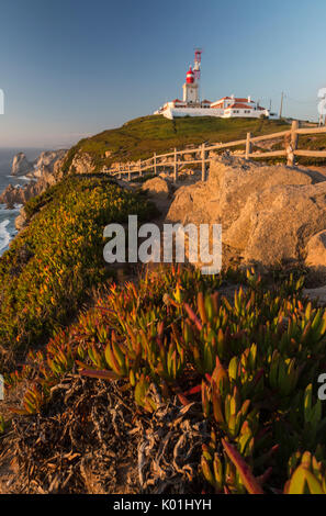 Il Cabo da Roca faro domina il promontorio verso l'Oceano Atlantico al tramonto Sintra Portogallo Europa Foto Stock