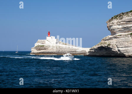 Barca in mare blu cristallino circondato dal granito bianche scogliere e faro Isole Lavezzi Bonifacio Corsica Francia Europa Foto Stock