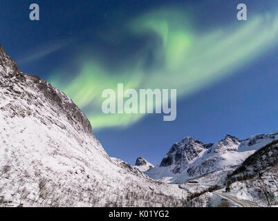 Panorama di luci del nord e stelle sulle cime innevate lungo la nazionale percorso turistico Bergsbotn Senja Tromsø Norvegia Europa Foto Stock