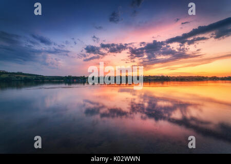 Bella scena con il fiume e il cielo colorato con le nuvole al tramonto. Un paesaggio fantastico con il lago, cielo blu con nuvole multicolore riflessa nell'acqua un Foto Stock