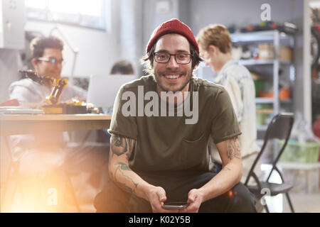 Ritratto sorride fiducioso designer maschio con un telefono cellulare Foto Stock