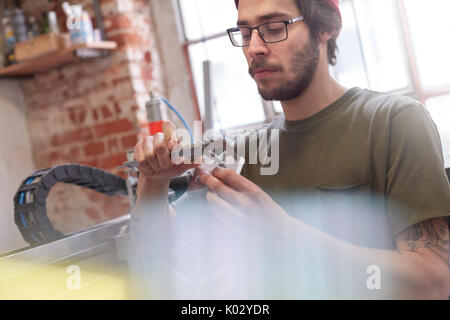 Designer maschio utilizzando i calibri in officina Foto Stock