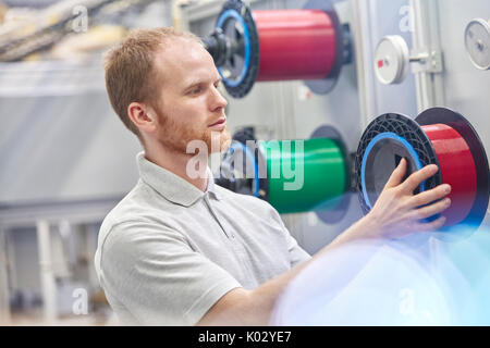 Lavoratore di sesso maschile cambiando lo stelo in fibre ottiche factory Foto Stock