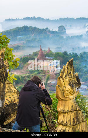 Mrauk-U, Stato di Rakhine, Myanmar. Uomo a scattare foto di Mrauk-U in una nebbiosa alba dalla Shwetaung pagoda. Foto Stock