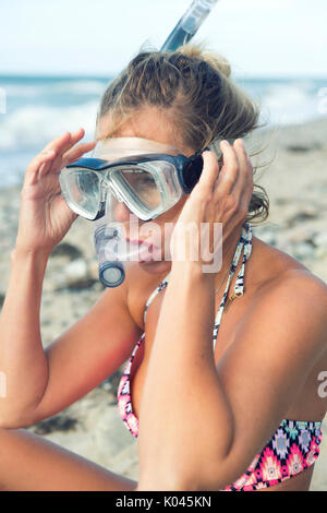 Ritratto di bella donna bionda con gli occhiali per nuoto in spiaggia Foto Stock