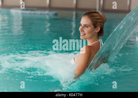 Ritratto di donna bella rilassante in piscina Foto Stock