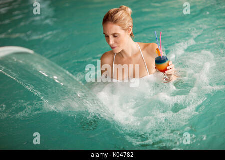 Ritratto di donna bella rilassante in piscina Foto Stock