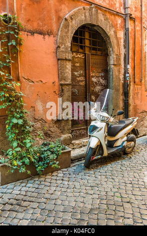 Scooter parcheggiato di fronte a una storica Porta Foto Stock