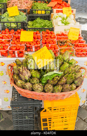 Artickokes e pomodori per la vendita in una fase di stallo a campodei fiori market Foto Stock