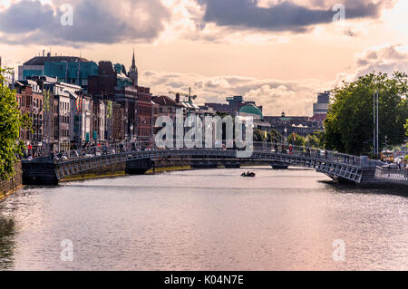 Persone attraversano Ha'penny Bridge attraverso il fiume Liffey nella capitale irlandese di Dublino Foto Stock