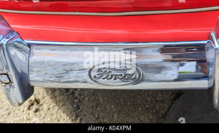 Ford marca auto logo sul metallo lucido paraurti del red American classic car, dettaglio shot Foto Stock