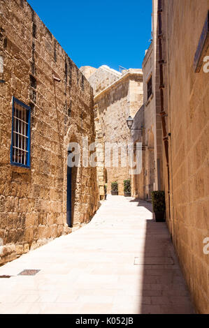 Una strada laterale in Victoria, la capitale dell'isola di Gozo nell'arcipelago Maltese. La ripresa è stata presa in una limpida giornata di sole. Foto Stock