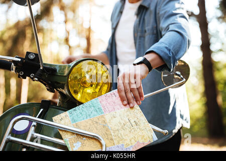 Immagine ritagliata della giovane azienda mappa all'esterno. Foto Stock