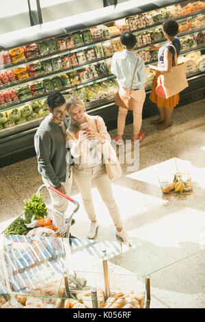 Coppia giovane tenendo selfie in drogheria market Foto Stock