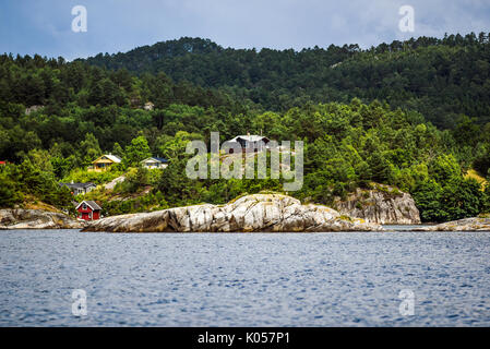 Il paesaggio di cottage su una roccia tra il verde al largo delle coste della Norvegia Foto Stock