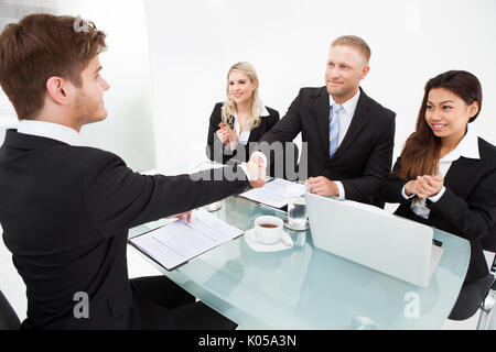 Business Partner stringono le mani alla scrivania in ufficio Foto Stock