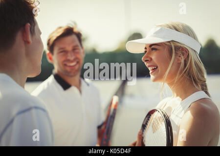 Maschio e femmina i giocatori di tennis a parlare sul campo da tennis Foto Stock