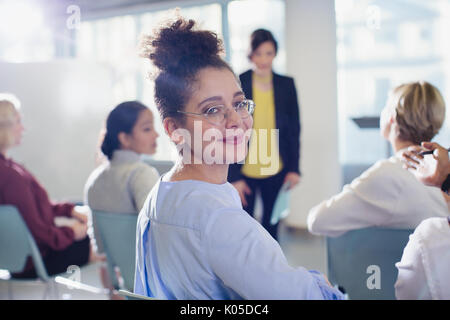 Ritratto sorridente, fiduciosi imprenditrice di tornitura, guardando indietro nel pubblico di conferenza Foto Stock