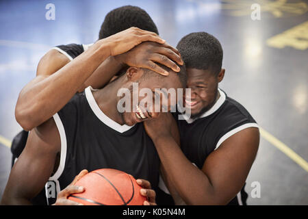 Felice maschi giovani giocatori di basket e abbraccia in festa dopo la vittoria Foto Stock