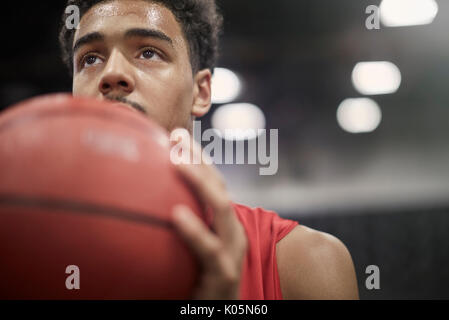 Close up focalizzata maschile giovane giocatore di basket tenendo la pallacanestro Foto Stock