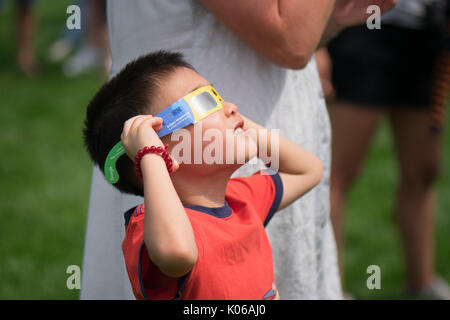 Amherst, STATI UNITI D'AMERICA. 21 Ago, 2017. Asian American boy guardare eclipse con occhiali speciali. Credito: Edgar Izzy/Alamy Live News Foto Stock