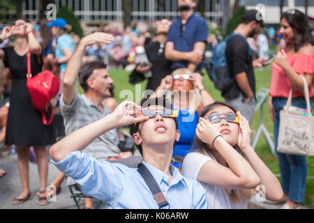 New York, Stati Uniti d'America. 21 Ago, 2017. Migliaia di curiosi si radunano in Bryant Park per guardare la parziale eclissi solare che si verificano in New York lunedì, agosto 21, 2017. New York City non è nel percorso della totalità con la luna che copre soltanto la quasi 72 percento del sole durante le 2:44PM picco. ( © Richard B. Levine) Credito: Richard Levine/Alamy Live News Foto Stock