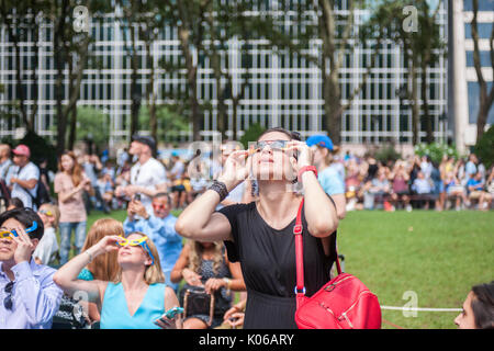 New York, Stati Uniti d'America. 21 Ago, 2017. Migliaia di curiosi si radunano in Bryant Park per guardare la parziale eclissi solare che si verificano in New York lunedì, agosto 21, 2017. New York City non è nel percorso della totalità con la luna che copre soltanto la quasi 72 percento del sole durante le 2:44PM picco. ( © Richard B. Levine) Credito: Richard Levine/Alamy Live News Foto Stock