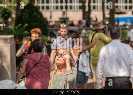 New York, Stati Uniti d'America. 21 Ago, 2017. Migliaia di curiosi si radunano in Bryant Park per guardare la parziale eclissi solare che si verificano in New York lunedì, agosto 21, 2017. New York City non è nel percorso della totalità con la luna che copre soltanto la quasi 72 percento del sole durante le 2:44PM picco. ( © Richard B. Levine) Credito: Richard Levine/Alamy Live News Foto Stock