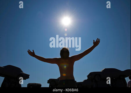 Alliance, Nebraska. 21 Ago, 2017. Tavon Boaman, da Ft. Collins, CO, adora sole durante le fasi iniziali della eclissi solare a Carhenge, vicino Alliance, Nebraska. Credito: Chuck Bigger/Alamy Live News Foto Stock