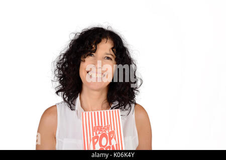 Ritratto di donna bella mangiare popcorn e guardare film. Isolato sullo sfondo bianco. Foto Stock