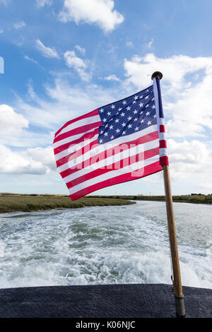 Inghilterra, sandwich. Bandiera americana svolazzante dalla poppa della barca. Vicino fiume e la scia della barca velocizzando dietro la bandiera. Foto Stock