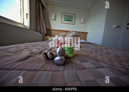 Due i peluche seduta sul letto in cabina della nave da crociera Foto Stock