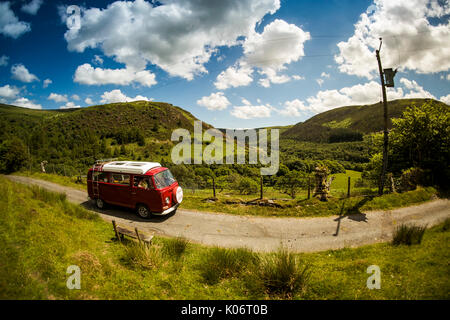 Estate nella valle del Wye: una donna di mezza età guidando il suo classico 1973 Volkswagen tipo due (T2) bay window red camper in vacanza lungo la scenic Wye Valley in Galles centrale su un caldo luglio mattina. La contea di Powys Wales UK Foto Stock