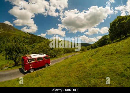 Estate nella valle del Wye: una donna di mezza età guidando il suo classico 1973 Volkswagen tipo due (T2) bay window red camper in vacanza lungo la scenic Wye Valley in Galles centrale su un caldo luglio mattina. La contea di Powys Wales UK Foto Stock