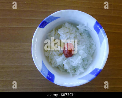Giapponese di riso bianco e umeboshi (prugna pickle) sul tavolo di legno Foto Stock