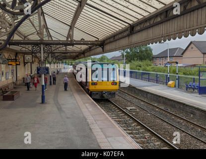 Il corpo di guardia del 1559 Chester - Manchester Piccadilly ferroviaria settentrionale 142 classe treno pacer controlla le porte prima della partenza da Northwich, Cheshire Foto Stock