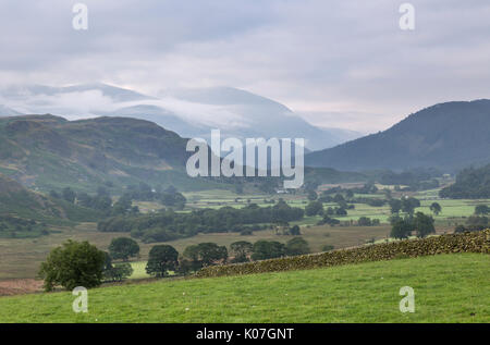 Guarda se dal Castello Rigg cerchio di pietra, con la valle del Naddle Beck in primo piano, Alta Rigg, e Helvellyn - protetto in nuvole - al di là di Foto Stock