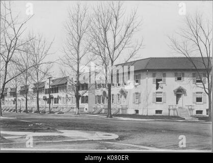 A livello stradale e shot di bianco a due piani di riga-case con gradini che conducono alla porta anteriore, alberi senza foglie nella parte anteriore del case, Roland parco/Guilford, Stati Uniti, 1910. Questa immagine viene da una serie di documentare la costruzione e la vendita di case nel parco di Roland/Guilford quartiere di Baltimora, un tram sobborgo e una delle prime comunità prevista negli Stati Uniti. Foto Stock