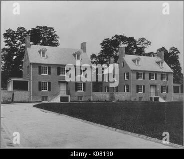 Fotografia dei due quasi identico a due piani di Roland Park Homes in Baltimore, entrambe realizzate quasi interamente in cotto, ornato di finestre e persiane, grandi alberi che si profila in background, le case accanto a un grande campo frammentarie, Stati Uniti, 1920. Questa immagine viene da una serie di documentare la costruzione e la vendita di case nel parco di Roland/Guilford quartiere di Baltimora, un tram sobborgo e una delle prime comunità prevista negli Stati Uniti. Foto Stock