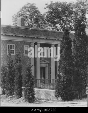 Fotografia di un due-storia Roland Park home a Baltimora, con colonne doriche e piccole finestre, circondato da piccoli alberi e cespugli, Stati Uniti, 1920. Questa immagine viene da una serie di documentare la costruzione e la vendita di case nel parco di Roland/Guilford quartiere di Baltimora, un tram sobborgo e una delle prime comunità prevista negli Stati Uniti. Foto Stock