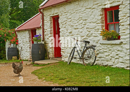 Bicicletta appoggiata contro una parete bianca cottage