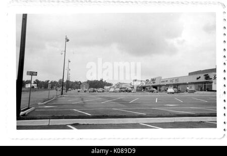 Fotografia del parcheggio per la Northwood Shopping Centre, mostrando le automobili sparse, lampioni, ed edifici commerciali come il Teatro Northwood, con gli edifici residenziali e commerciali e gli alberi in background, Baltimore, Maryland, 1951. Foto Stock