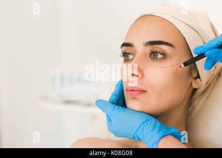 Disegno Medico segni sul volto femminile contro uno sfondo bianco. Foto Stock