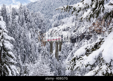 Il Bernina Express il trenino rosso come si passa sopra il ponte Landwasser, Filisur, Grigioni, Svizzera, Europa. Foto Stock