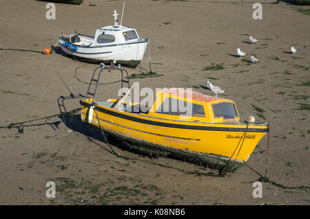 2 barche da pesca (1 bianco e 1 giallo) spiaggiata sulla sabbia in Margate Harbour a bassa marea con i gabbiani Foto Stock
