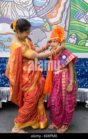 Un fmother regola la sua figlia di costume appena prima dell'inizio del 2017 India parata del giorno a Manhattan, New York City. Foto Stock