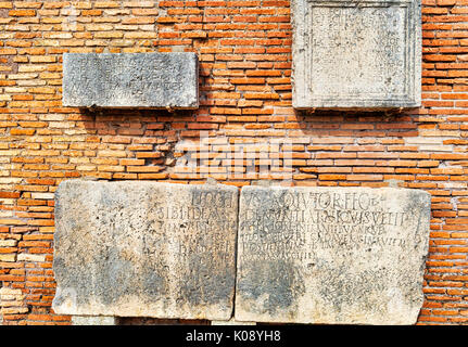 Gli scavi archeologici di Ostia Antica: muro romano con marmi incisi con lettere latine. Foto Stock