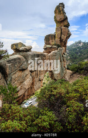 Una vettura si avvolge la curvatura autostrada di montagna oltre un arco in pietra nella Santa Catalina Mountains vicino a Tucson, AZ. Foto Stock