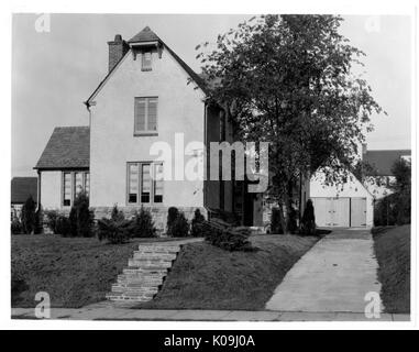 Fotografia di un due-storia home in Guilford quartiere di Baltimora, con un piccolo vialetto, una semplice facciata, una recessione portico anteriore e piccoli arbusti sul curato prato anteriore, Baltimore, Maryland, 1935. Questa immagine viene da una serie di documentare la costruzione e la vendita di case nel parco di Roland/Guilford quartiere di Baltimora, un tram sobborgo e una delle prime comunità prevista negli Stati Uniti. Il quartiere era segregato ed è considerato uno dei primi esempi di applicazione della segregazione razziale attraverso l'uso limitato di patti. Foto Stock