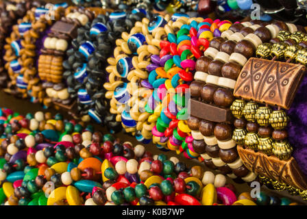 Close up di luminoso in legno colorato bracciali intrecciato con perle al mercato di strada a Mosca, Russia. Foto Stock